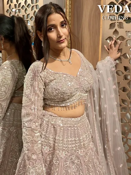 The perfect pose to show off the beautiful details and the soft, romantic color of this pink lehenga.