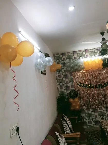 A simple and elegant home decoration for a birthday party. A balloon arch over a shimmer curtain can instantly make your living room feel festive.