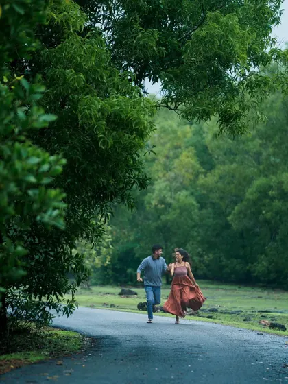 A candid shot of a couple running joyfully down a path surrounded by lush greenery. This photo captures a feeling of freedom and happiness, showcasing my ability to capture unscripted, natural moments.