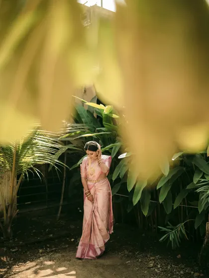 The bride in a full-length shot, framed by foliage, creating a sense of being in a secret garden.