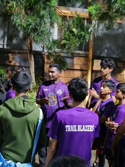 A coach debriefing his team, the Trail Blazers, after a match. We focus on learning from every win and every loss.