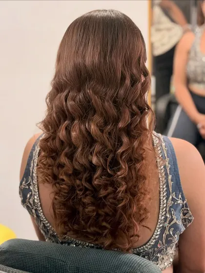 A back view of perfectly formed, voluminous curls. In my hairstyling classes, we cover techniques for creating different types of curls that last all day.