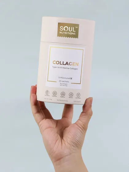 A clean and minimalist shot of a collagen supplement. The hand holding the product gives it a personal, user focused feel, while the simple background keeps the focus on the elegant packaging.
