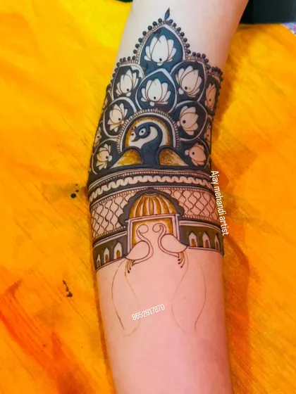 This design showcases a beautiful peacock surrounded by lotus flowers at the top of the arm, creating an elegant cuff-like pattern.