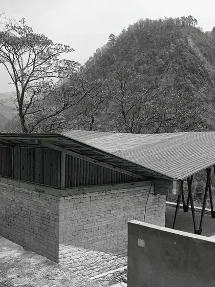 **Angling Centre, Pancheshwar:** A black and white shot emphasizing the form and texture of the building. The contrast highlights the relationship between the solid stone base and the lightweight roof structure.