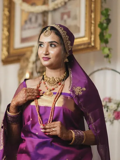 A portrait of a bride ready for her Oorkuduva ceremony, wearing the traditional head covering. Her makeup is soft and elegant, with a focus on her eyes.