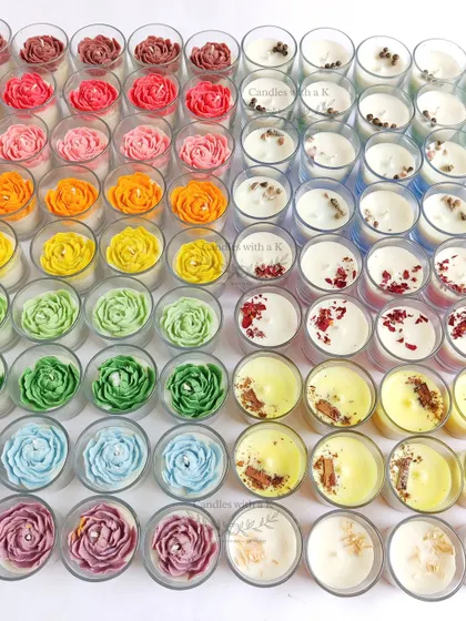 A rainbow of housewarming candles, showing the full variety of peony flower colors and layered candles with spice toppings.