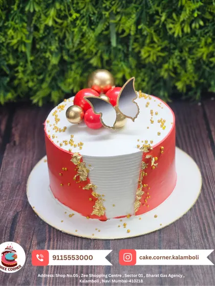 An elegant red and white cake with butterfly and sphere decorations. The fault line design with gold leaf adds a modern and sophisticated touch.