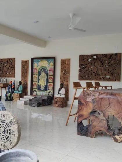 A showroom view of various Bali-style furniture and sculptures I supply, including wooden wall art and tables.