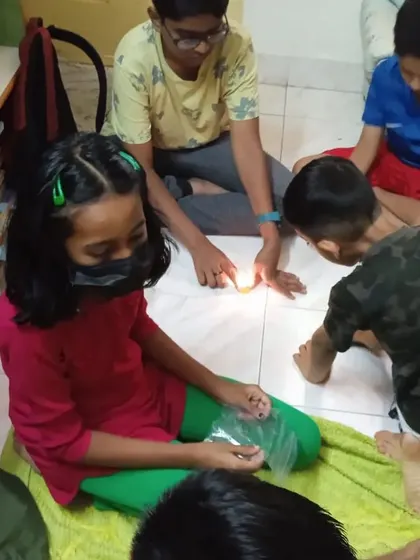 A group of students works together on a hands-on light experiment.