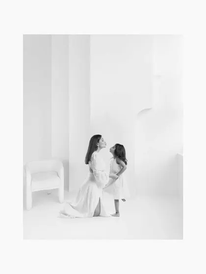 The same tender moment between mother and daughter, rendered in emotional black and white. The lack of color emphasizes their expressions and the deep bond they share.