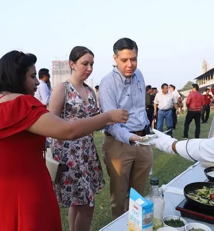 Our chef serving international guests at an outdoor event. We are experienced in catering to diverse palates and ensuring every guest has a wonderful dining experience with our professional service.