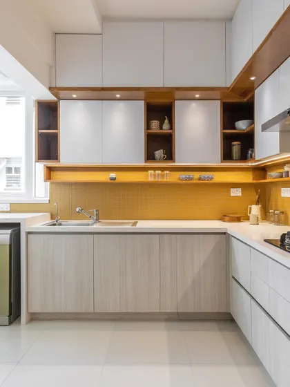 This kitchen combines light wood-grain laminates with a vibrant yellow backsplash and under-cabinet lighting for a warm and modern look.