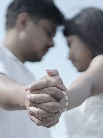 A close-up of a couple holding hands, their foreheads touching, symbolizing their deep connection.
