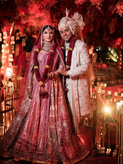 The final wedding day look for Natasha and Pranshu. Her burgundy-accented lehenga and his classic ivory sherwani create a timeless and regal portrait.
