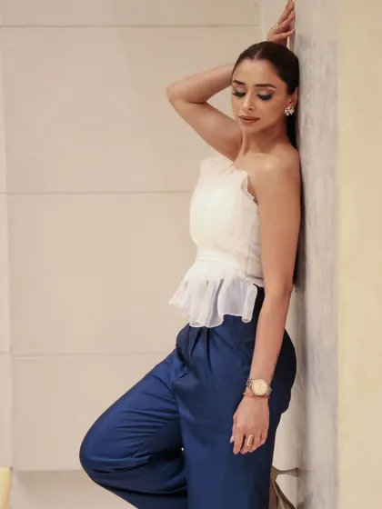A side profile showcasing the subtle contouring and sleek ponytail. The makeup is understated yet polished, ideal for a fashion-forward photoshoot.