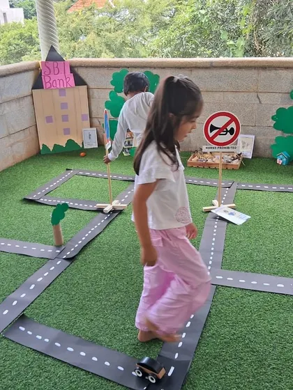 Imagination takes center stage in our miniature community role-play area. Children explore real-world concepts like road safety and community roles by driving toy cars through a town they helped create, turning abstract ideas into tangible fun.