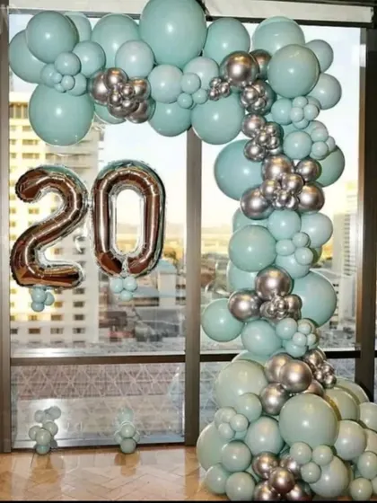 This budget-friendly balloon arch in pastel green and silver is perfect for home decor. It beautifully frames the window and the city view, adding a celebratory feel for a 20th birthday.