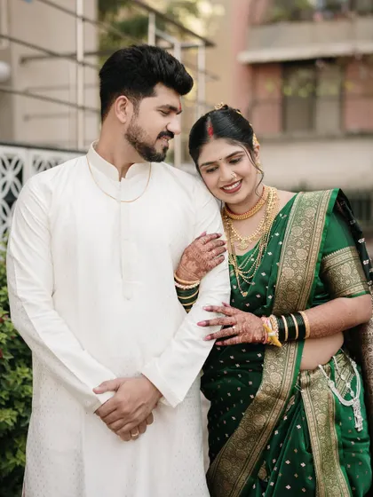 A tender moment of connection, with the bride resting her head on her partner's shoulder, showcasing her beautiful traditional jewelry and hairstyle.