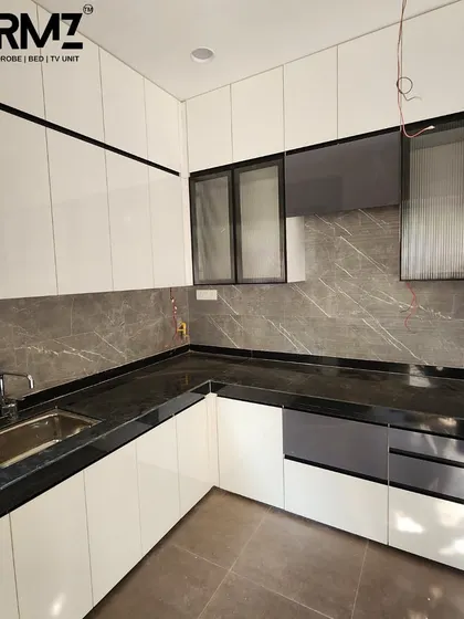 Another angle of the white U-shaped kitchen, focusing on the sink area and surrounding cabinetry. The combination of solid and fluted glass doors adds visual texture to the space.