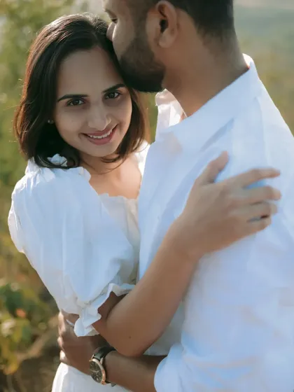 A gentle kiss on the forehead, a simple yet powerful gesture of love captured during a sunny outdoor pre-wedding shoot.