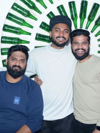 Friends posing against the iconic bottle wall. The venue's vibe is an important part of the overall experience.