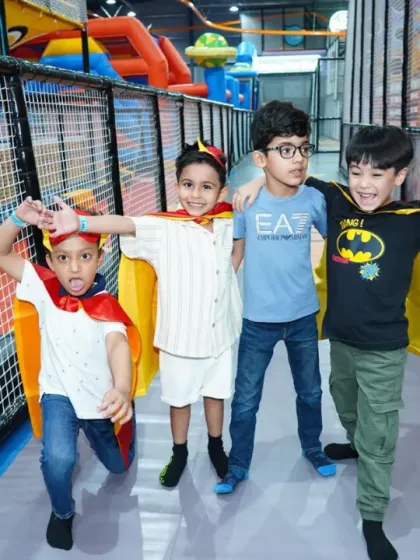A team of young superheroes! These friends are having a blast at a Superman-themed party, complete with capes for all the guests.