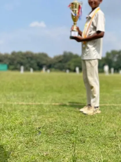 A low-angle shot capturing a young player holding his trophy, symbolizing the heights he can reach with dedication.