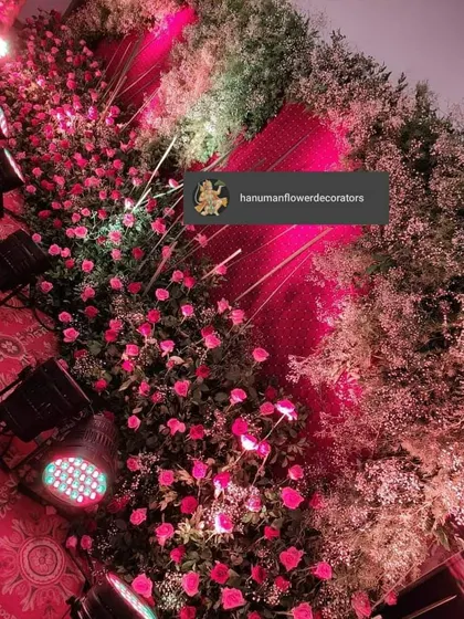 Another angle of the dense rose arrangement, showing how the pink lighting enhances the color of the flowers. This kind of floral decor adds a feeling of opulence to any celebration.