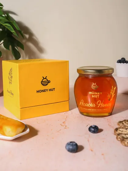 Product and packaging shot for Honey Hut's Acacia Honey. Showing the box alongside the product is important for e-commerce and retail visuals.