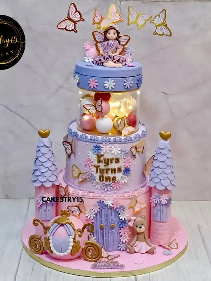 This two-tier chocolate ganache cake transforms a birthday into a royal ball. We designed it as a fairytale castle, complete with towers, a rotating top tier with a doll, and a magical illuminated spacer that brings the entire creation to life.