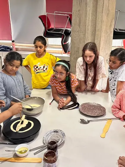 Children gather around a table for a hands-on crêpe-making workshop during our Summer Camp. Our camp is filled with fun, creative, and delicious activities that introduce kids to French culture.