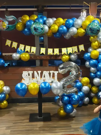 An under-the-sea adventure with this Little Mermaid theme for Shavni's second birthday. The blue, silver, and gold balloons create a water-like effect, complete with mermaid foil balloons.