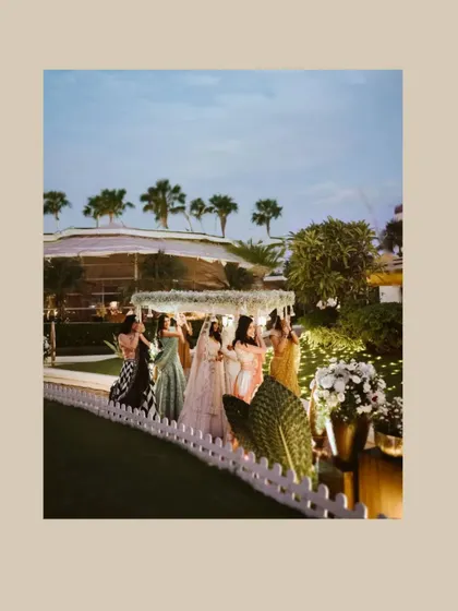 The bride's grand entrance under a beautiful phoolon ki chadar, surrounded by her loved ones.