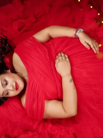 A vibrant overhead shot of the mom-to-be resting on a sea of red fabric. The rich color and soft lighting create a passionate and beautiful image.