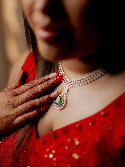 A close-up shot of the bride's stunning emerald and diamond necklace, a beautiful detail from her reception look.