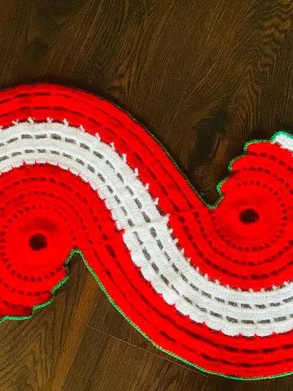 A top-down view of the red and white spiral Christmas runner, showing its unique shape.