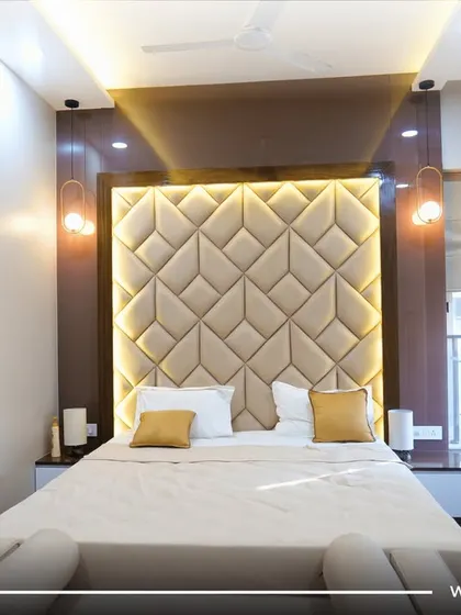 A bedroom that exudes glamour. The tufted, geometric headboard with backlighting is the undeniable star of this luxurious space.