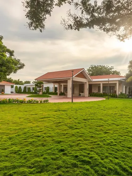 The sprawling lawn of the Greenfield farmhouse, designed to provide ample open space for recreation and events. The architecture is positioned to overlook these green expanses, connecting the home to its landscape.