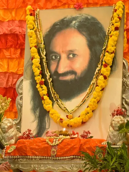 A portrait of me decorated with flowers and a lamp for Guru Purnima. Devotees gather to offer their respects and gratitude on this auspicious full moon day.