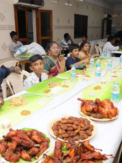 A family enjoying the full spread on a traditional banana leaf, complete with biryani, fried chicken, and various side dishes. This is what a true South Indian feast looks like.
