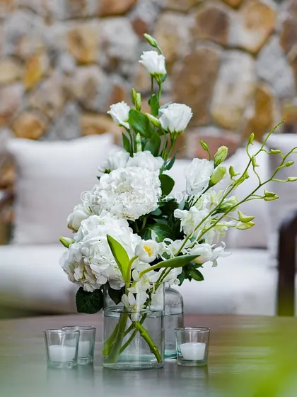 A simple, elegant bouquet of white hydrangeas and orchids sits on a coffee table in our lounge area. This detail shows how we carry our aesthetic through every space.