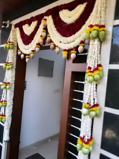 An elegant door decoration using hanging garlands of jasmine and lotus buds. This design is subtle yet beautiful, perfect for creating a serene atmosphere.