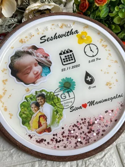 The combination of the dark mango wood hoop, the white resin, and the pink glitter creates a sweet and charming design for a baby girl's room.