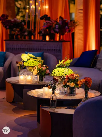 A closer look at the lounge seating, with small, vibrant floral arrangements on the coffee tables. Even in a relaxed setting, the decor details reinforce the dramatic 'Fire and Ice' color story.