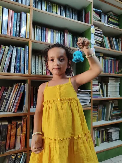 Look at this little champion proudly showing off her octopus keychain! It is a small token, but it represents a big achievement in her reading journey.
