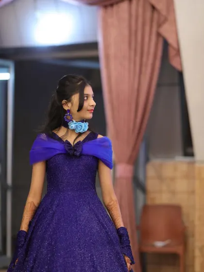 A side profile of the royal blue gown, showing the off-shoulder neckline and the custom floral choker we designed to match.