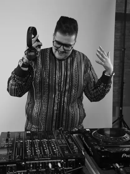 A candid black and white shot of me enjoying the moment behind the decks. You can see the smile on my face; this is my happy place, creating vibes and making people dance.