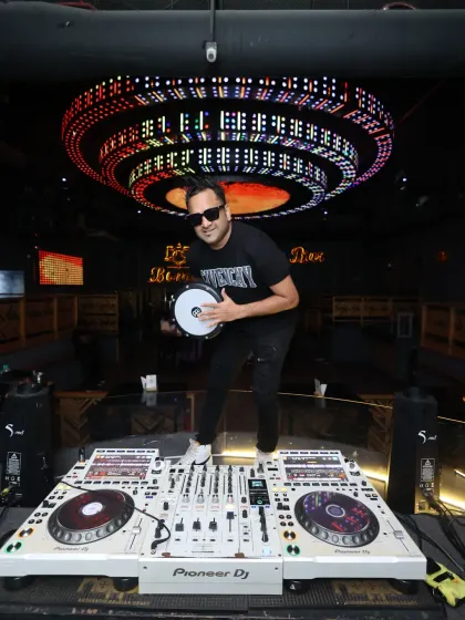Here I am in my element at Bombay Cocktail Bar, ready to drop the beat. With my Pioneer DJ setup and my Darbuka drum, I'm prepared to deliver a unique set that blends electronic music with live tribal rhythms.
