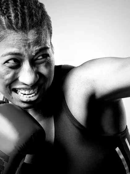 The power of an athlete. This black and white portrait of boxer Lovlina Borgohain captures the grit and determination in a single, intense moment of action. The focus is purely on her expression and the physicality of her sport.